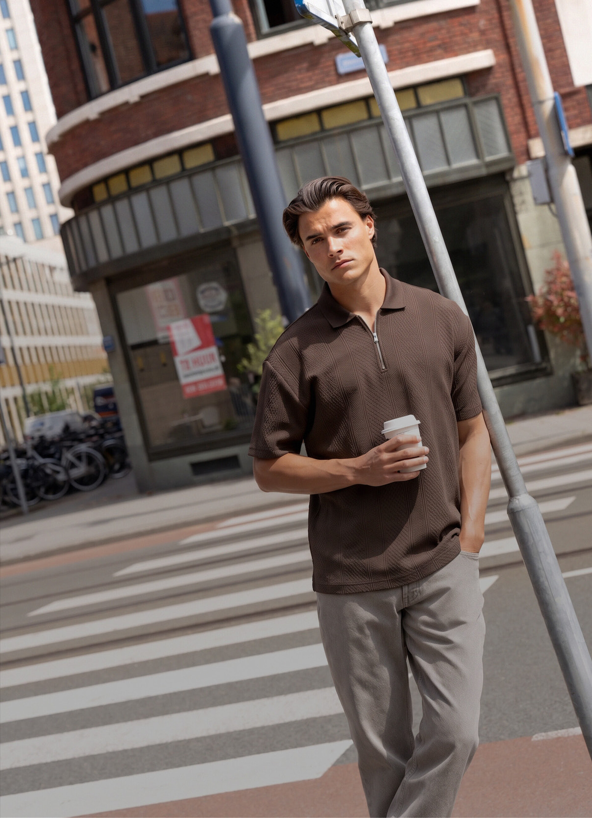 Nieuwe herencollectie van Shoeby met een donkerbruine polo en een lichtgrijze baggy fit jeans